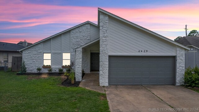 view of front of house featuring a garage and a yard