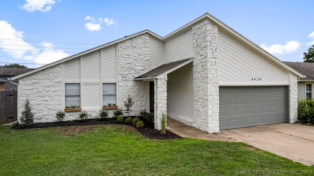 view of front of home with a garage and a front lawn