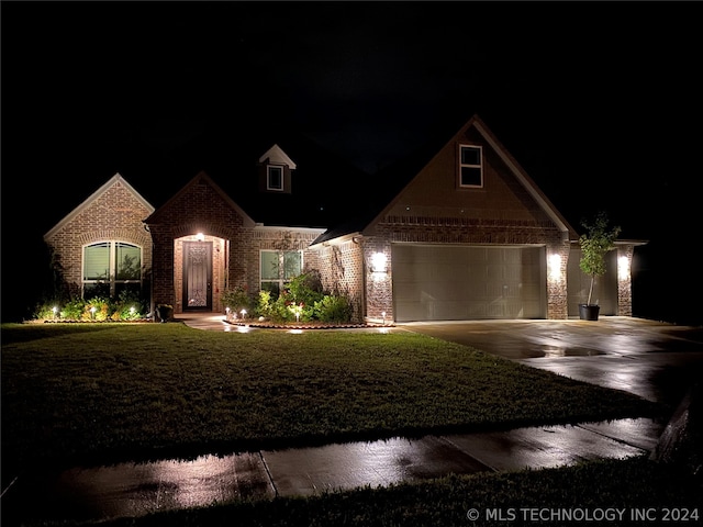 view of front of property with a garage and a yard