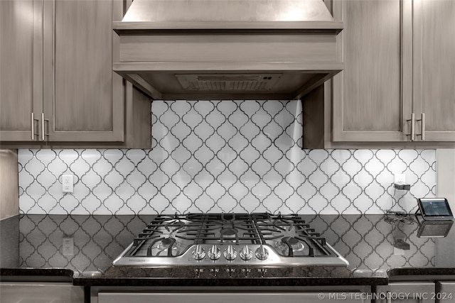 kitchen featuring stainless steel gas cooktop, tasteful backsplash, and custom range hood