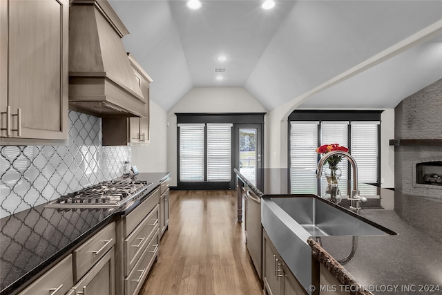 kitchen with gas stovetop, custom exhaust hood, hardwood / wood-style floors, decorative backsplash, and sink