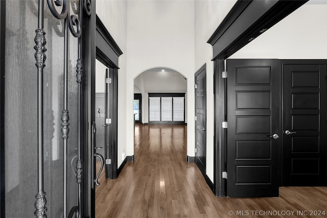 hallway featuring dark hardwood / wood-style flooring and a towering ceiling