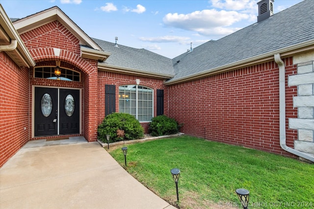 doorway to property with a lawn