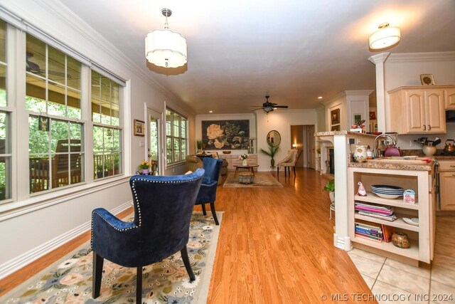 dining area with crown molding, ceiling fan, sink, and light hardwood / wood-style flooring