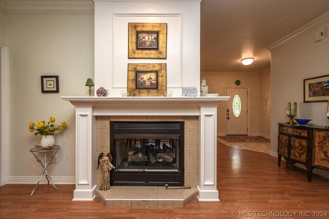 details featuring ornamental molding, hardwood / wood-style floors, and a fireplace