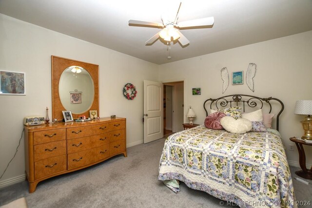 bedroom with ceiling fan and light colored carpet