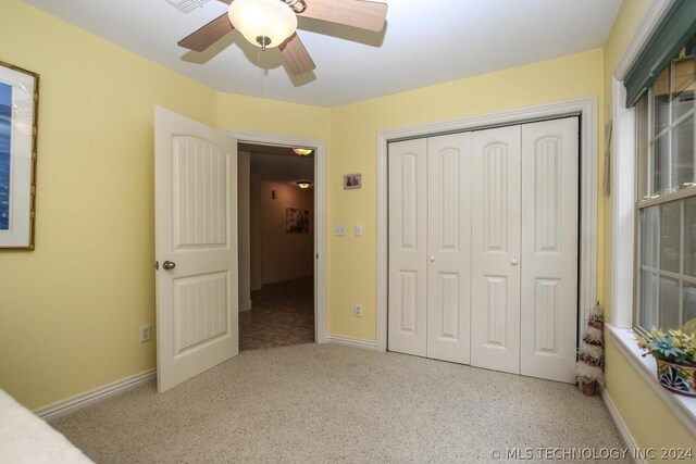 unfurnished bedroom featuring ceiling fan and a closet