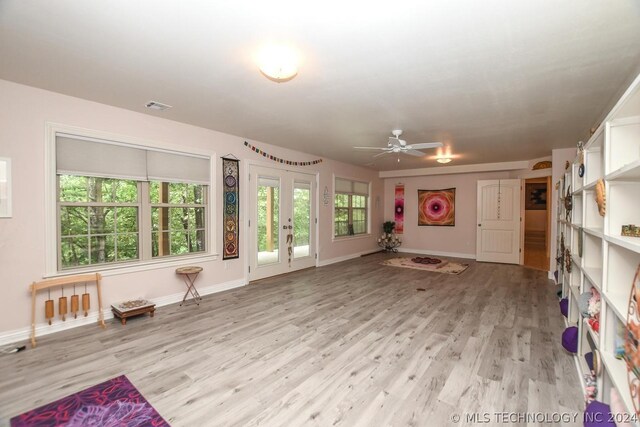 unfurnished living room featuring ceiling fan and light wood-type flooring