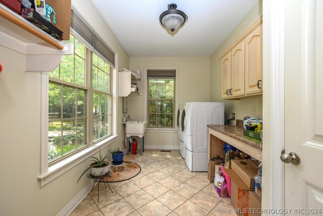 laundry area with cabinets, light tile patterned floors, and washer / clothes dryer