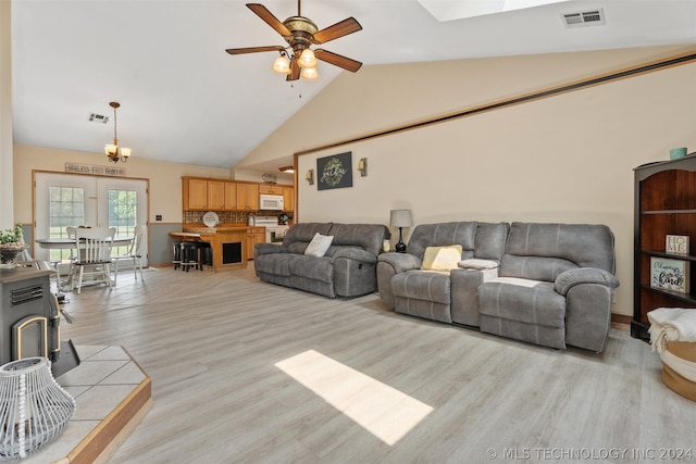 living room featuring ceiling fan, light hardwood / wood-style floors, and vaulted ceiling