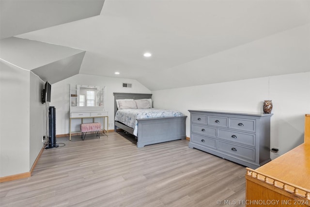 bedroom featuring light hardwood / wood-style floors and lofted ceiling