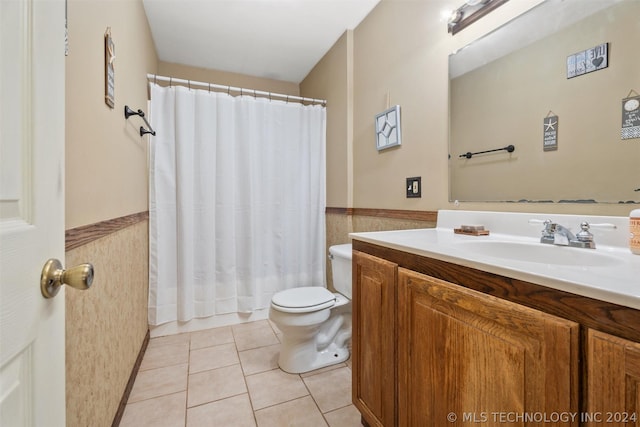 bathroom with a shower with curtain, tile patterned floors, toilet, vanity, and tile walls