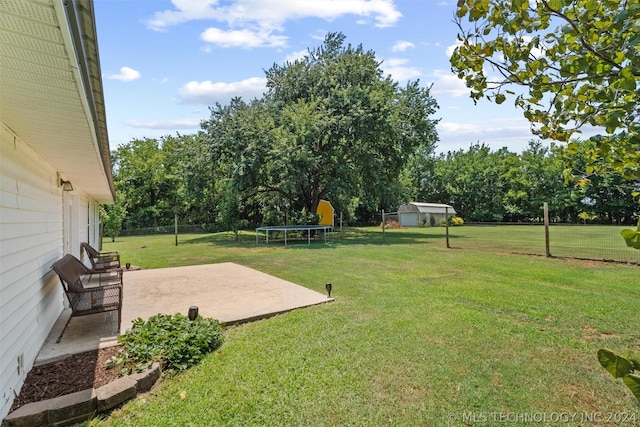 view of yard featuring a trampoline and a patio area