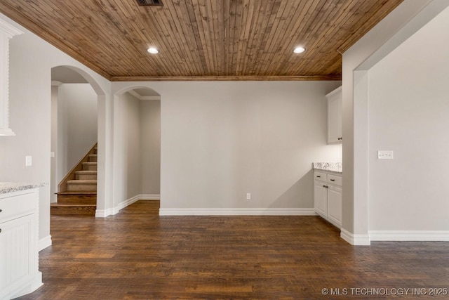 spare room with dark wood-type flooring, wooden ceiling, and recessed lighting