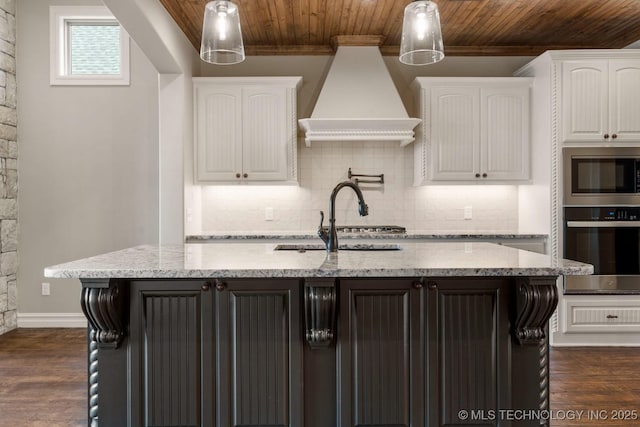 kitchen with a sink, appliances with stainless steel finishes, wooden ceiling, and custom exhaust hood