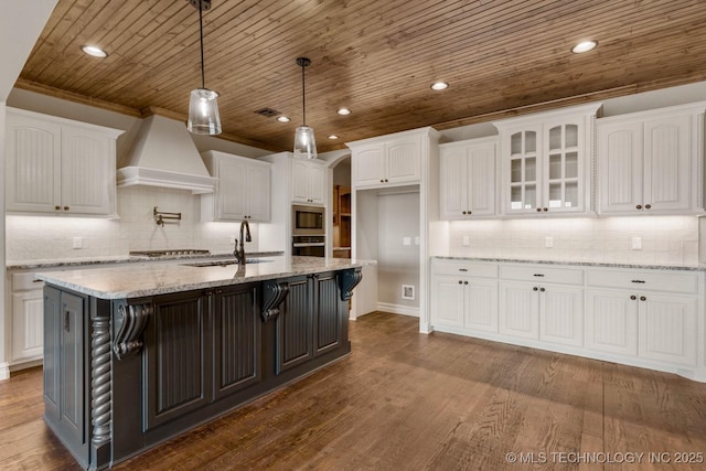 kitchen featuring dark wood finished floors, custom exhaust hood, stainless steel appliances, white cabinetry, and a sink