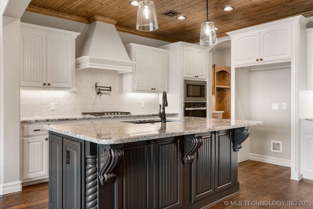 kitchen with stainless steel appliances, custom range hood, visible vents, white cabinets, and a sink