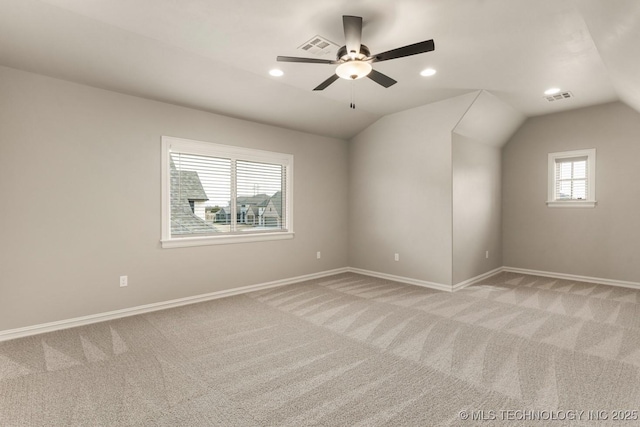 empty room featuring lofted ceiling, visible vents, and light colored carpet