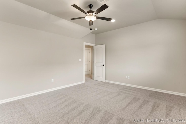 carpeted empty room featuring lofted ceiling, ceiling fan, visible vents, and baseboards