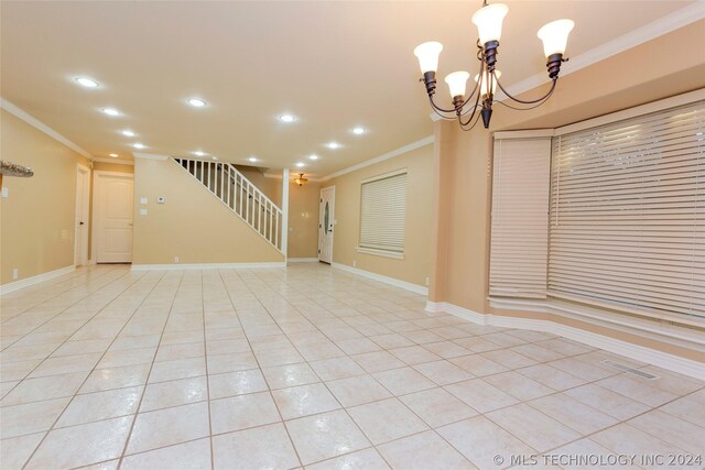 tiled empty room with ornamental molding and a chandelier