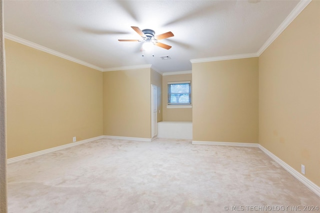 carpeted spare room with ceiling fan and ornamental molding