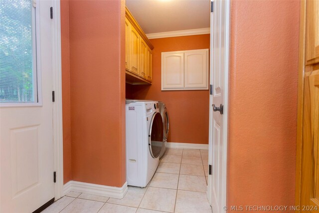 clothes washing area with washer and clothes dryer, light tile patterned floors, cabinets, and ornamental molding