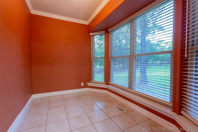 unfurnished room with light tile patterned floors and ornamental molding