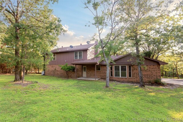 back of house featuring a yard and a patio