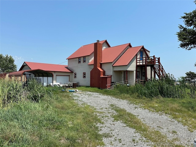 back of house with a carport and a garage