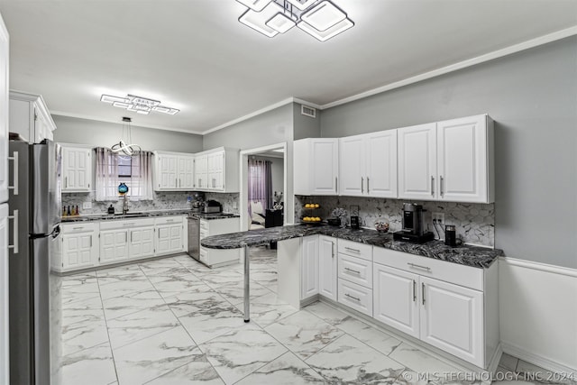 kitchen with white cabinets, stainless steel fridge, a kitchen bar, and hanging light fixtures