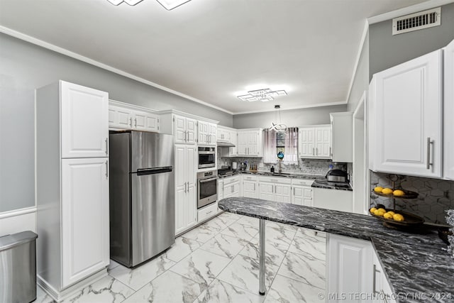 kitchen with decorative backsplash, white cabinetry, stainless steel appliances, and hanging light fixtures