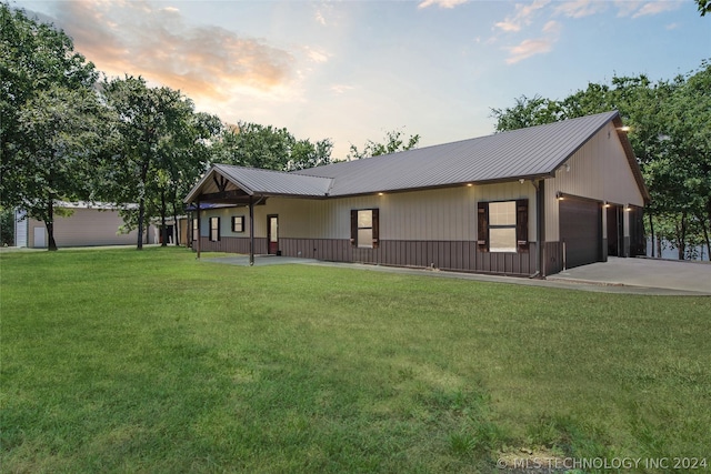 view of front of property featuring a garage and a lawn