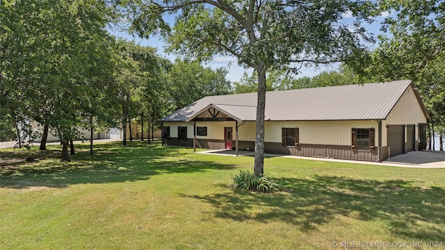 view of front facade featuring a garage, an outbuilding, and a front yard