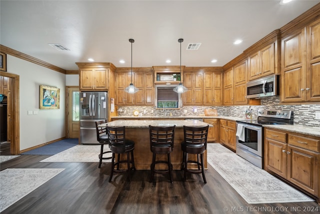 kitchen with appliances with stainless steel finishes, hanging light fixtures, decorative backsplash, dark hardwood / wood-style floors, and a center island