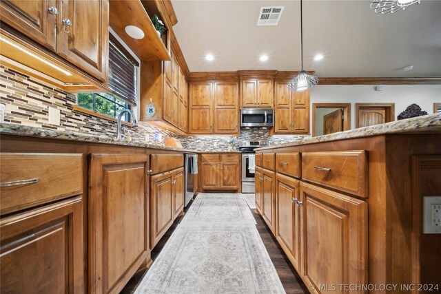 kitchen featuring tasteful backsplash, hanging light fixtures, appliances with stainless steel finishes, and light stone counters