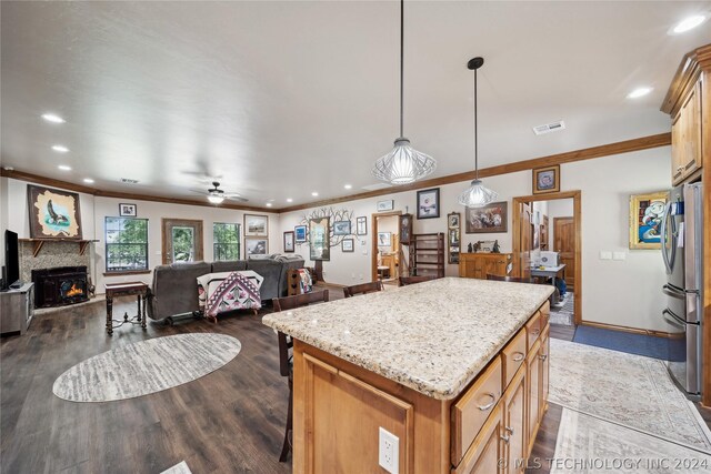 kitchen with a kitchen island, ceiling fan, dark hardwood / wood-style floors, and hanging light fixtures