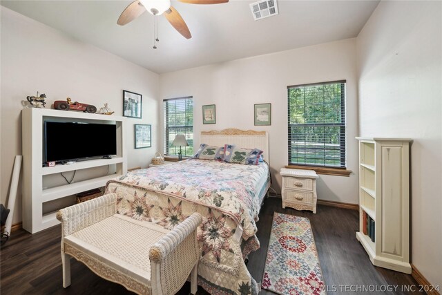 bedroom with dark wood-type flooring, ceiling fan, and multiple windows