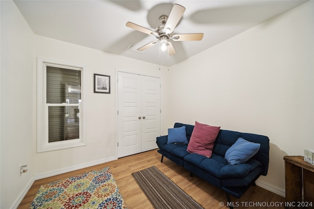 living room with light hardwood / wood-style flooring and ceiling fan