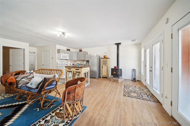 interior space with a wood stove, light hardwood / wood-style flooring, and plenty of natural light