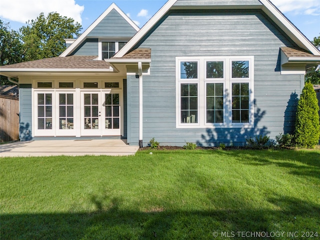 rear view of house with french doors and a lawn