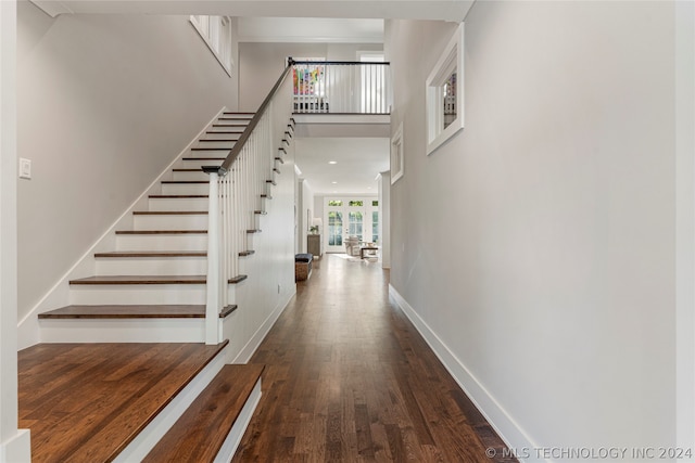 interior space with a high ceiling and dark wood-type flooring