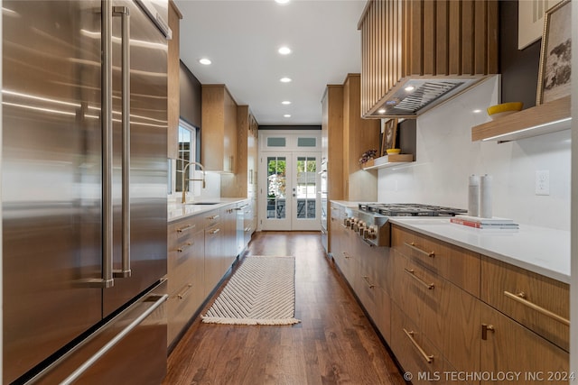 kitchen with french doors, dark hardwood / wood-style flooring, light stone counters, stainless steel appliances, and sink