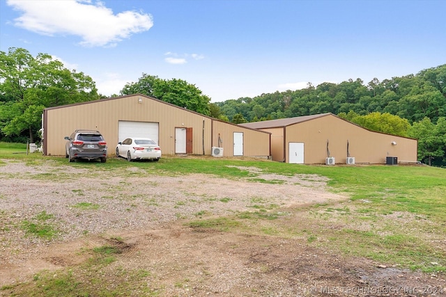 exterior space with an outbuilding, central AC unit, and a garage