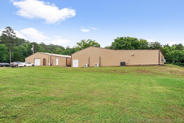 view of yard with a garage, an outbuilding, and cooling unit