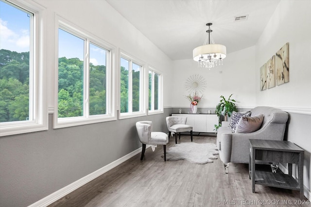 sitting room with radiator, an inviting chandelier, and hardwood / wood-style floors