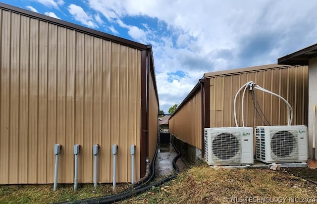 view of side of home featuring an outbuilding and ac unit