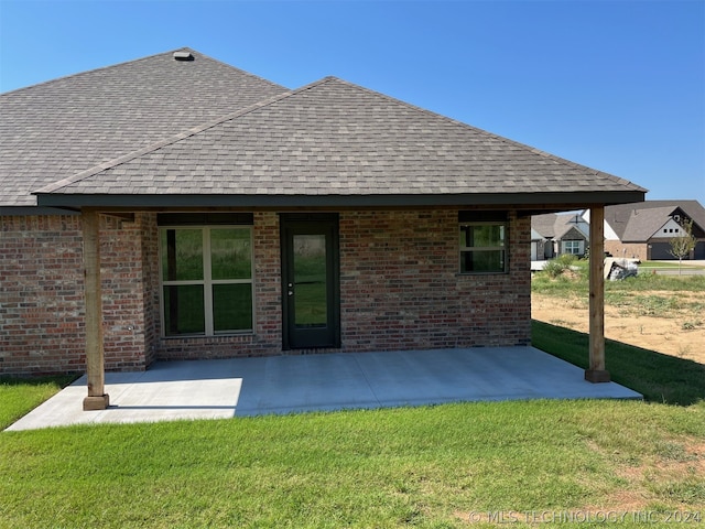 back of house featuring a patio area and a lawn