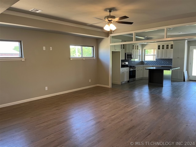 kitchen with dark hardwood / wood-style floors, tasteful backsplash, stainless steel appliances, and white cabinets