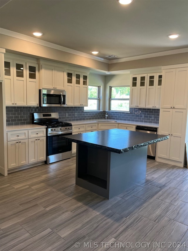 kitchen featuring white cabinets, tasteful backsplash, appliances with stainless steel finishes, and sink