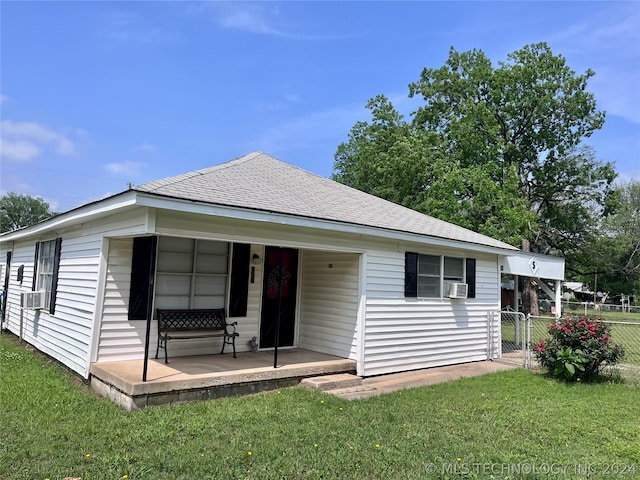 rear view of property with a lawn and cooling unit